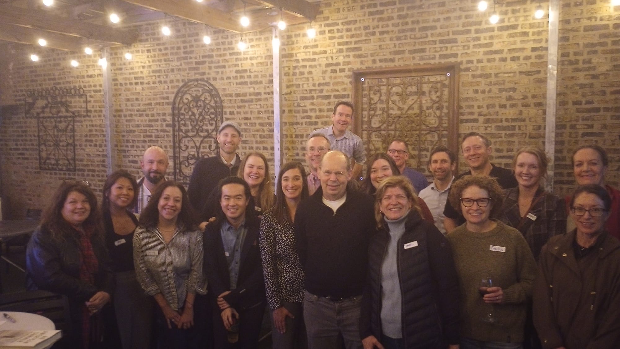 Author Alex Kotlowitz, a tall, bald man with glasses, stands in the middle of a group of educators.