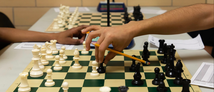 Two Chicago public schools students play chess on a cafeteria table.