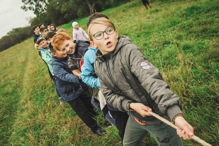 A team of children pull a rope in tug-of-war.